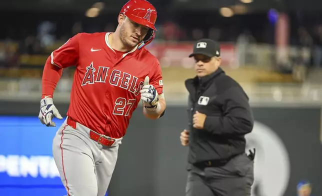 Los Angeles Angels' Mike Trout, left, rounds the bases after hitting a home run against the Minnesota Twins during the seventh inning of a baseball game, Friday, April 25, 2025, in Minneapolis. (AP Photo/Craig Lassig)