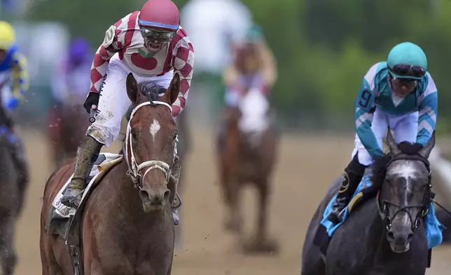 Umberto Rispoli, left, atop Journalism, reacts after edging out Luis Saez, atop Gosger, to win the the 150th running of the Preakness Stakes horse race Saturday, May 17, 2025, at Pimlico Race Course in Baltimore. (AP Photo/Nick Wass)