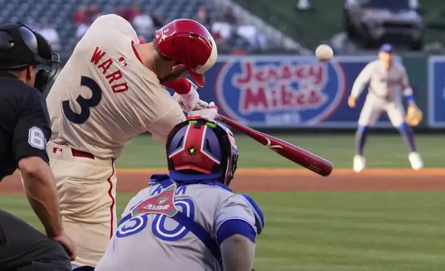 Los Angeles Angels' Taylor Ward, center, hits a two-run home run as Toronto Blue Jays catcher Alejandro Kirk watches during the first inning of a baseball game Thursday, May 8, 2025, in Anaheim, Calif. (AP Photo/Mark J. Terrill)