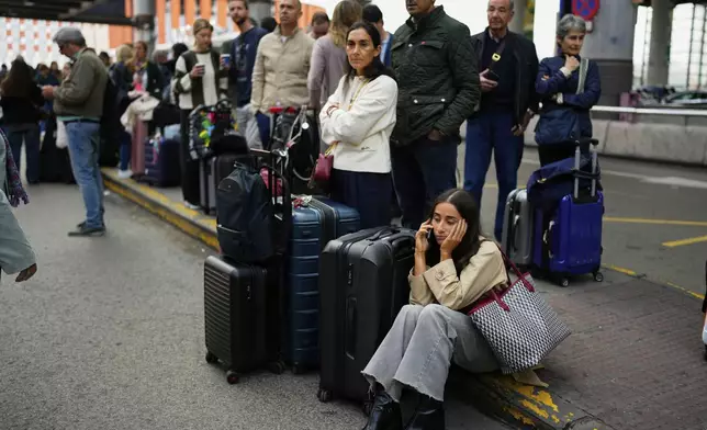 Travelers wait for news about their delayed trains at the Madrid train station, Spain, Monday, May 5, 2025. (AP Photo/Manu Fernandez)
