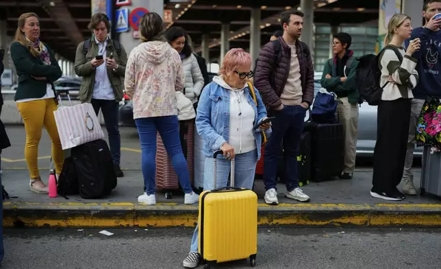 Travelers wait for news about their delayed trains at the Madrid train station, Spain, Monday, May 5, 2025. (AP Photo/Manu Fernandez)