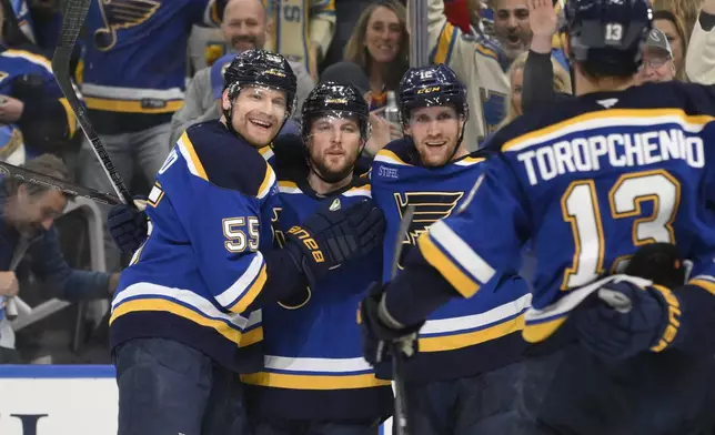 St. Louis Blues defenseman Cam Fowler (17) is congratulated by teammates after scoring against the Winnipeg Jets during the second period in Game 6 of an NHL hockey first-round playoff series Friday, May 2, 2025, in St. Louis. (AP Photo/Jeff L)