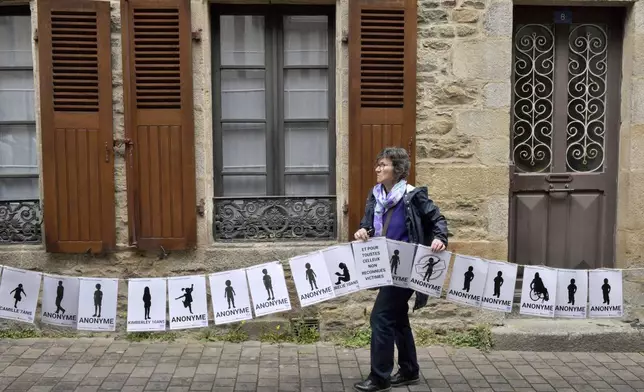 A woman holds a banner representing anonymous victims during a demonstration ahead of the verdict in the trial of Joel Le Scouarnec, a 74-year-old former surgeon, accused of raping and sexually assaulting 299 children, Wednesday, May 28, 2025 in Vannes, Brittany, western France. (AP Photo/Mathieu Pattier)