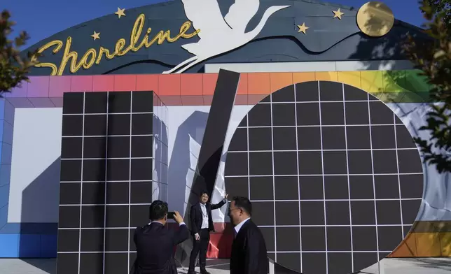 People pose for photos in front of an I/O logo at a Google I/O event in Mountain View, Calif., Tuesday, May 20, 2025. (AP Photo/Jeff Chiu)