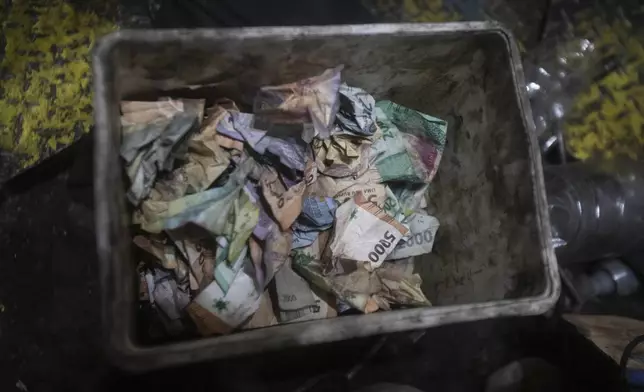 Tip money is collected put in a tub after a "wall of death" performance at a fairground in Medan, North Sumatra, Indonesia, Saturday, May 10, 2025. (AP Photo/Binsar Bakkara)