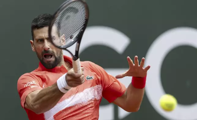 Serbia's Novak Djokovic returns a ball to Hungary's Marton Fucsovics during the round of 16 match at the ATP 250 Geneva Open Tennis Tournament, in Geneva, Switzerland, Wednesday, May 21, 2025 (Cyril Zingaro/Keystone via AP)