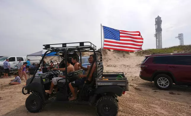 Beachgoers spend the afternoon on the beach as SpaceX's mega rocket Starship is prepared for a test flight from Starbase, Texas, Monday, May 26, 2025. (AP Photo/Eric Gay)