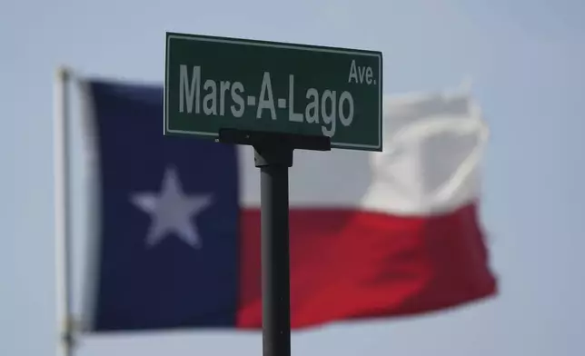 An unofficial street sign stands near a Texas flag as SpaceX's mega rocket Starship is prepared for a test flight from Starbase, Texas, Tuesday, May 27, 2025. (AP Photo/Eric Gay)
