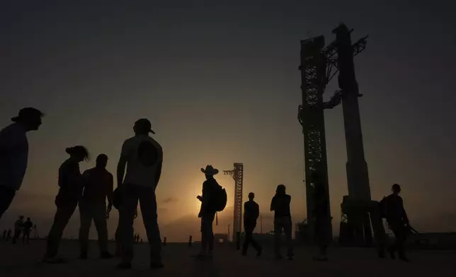 Onlookers watch as SpaceX's mega rocket Starship is prepared for a test flight from Starbase, Texas, Monday, May 26, 2025. (AP Photo/Eric Gay)