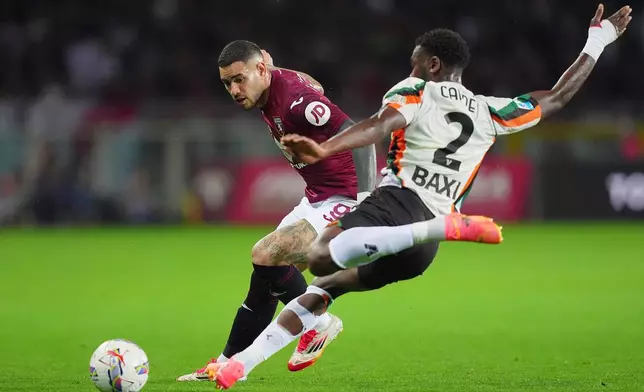 Torino's Antonio Sanabria, left, and Venezia's Fali Cande in action during the Serie A soccer match between FC Torino and Venezia at the Olympic Stadium in Turin, Italy, Friday May 2, 2025. (Spada/LaPresse via AP)