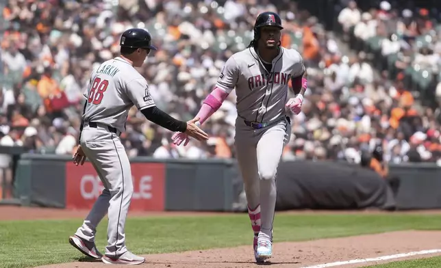 Arizona Diamondbacks' Ketel Marte, right, is congratulated by third base coach Shaun Larkin (88) after hitting a two-run home run during the fourth inning of a baseball game against the San Francisco Giants in San Francisco, Wednesday, May 14, 2025. (AP Photo/Jeff Chiu)