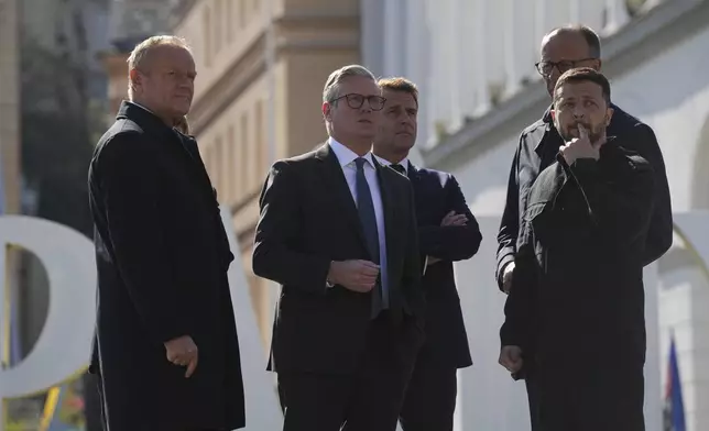 From left, Polish Prime Minister Donald Tusk, British Prime Minister Keir Starmer, French President Emmanuel Macron, German Chancellor Friedrich Merz, and Ukrainian President Volodymyr Zelenskyy, stand at the memorial of fallen Ukrainian soldiers at independence square in Kyiv, Ukraine, on Saturday, May 10, 2025. (AP Photo/Evgeniy Maloletka)
