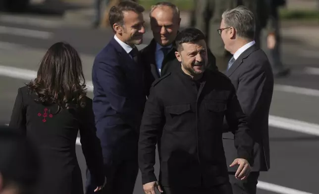 Ukrainian President Volodymyr Zelenskyy walks for a ceremony with French President Emmanuel Macron, Polish Prime Minister Donald Tusk and British Prime Minister Keir Starmer, at the memorial of fallen Ukrainian soldiers at independence square in Kyiv, Ukraine, on Saturday, May 10, 2025. (AP Photo/Evgeniy Maloletka)