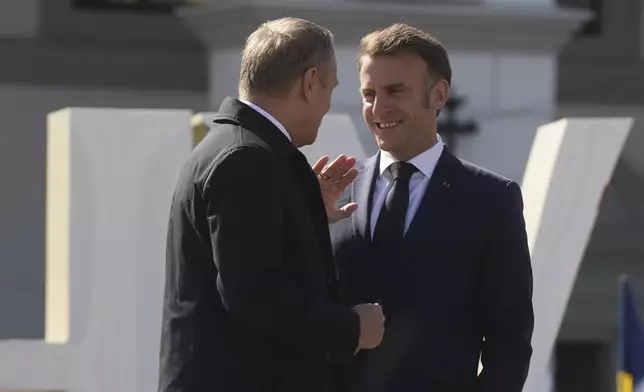 Polish Prime Minister Donald Tusk and French President Emmanuel Macron speak at the memorial of fallen Ukrainian soldiers at independence square in Kyiv, Ukraine, on Saturday, May 10, 2025. (AP Photo/Evgeniy Maloletka)