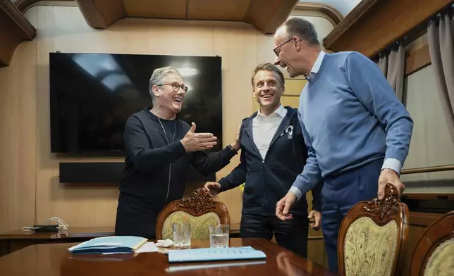 Britain's Prime Minister Keir Starmer, left, meets with French President Emanuel Macron, center, and German Chancellor Friedrich Merz onboard a train to Kyiv in Shegyni, Ukraine, where all three will hold meetings with Ukrainian President Volodymyr Zelenskyy, Friday, May 9, 2025. (Ludovic Marin, Pool Photo via AP)