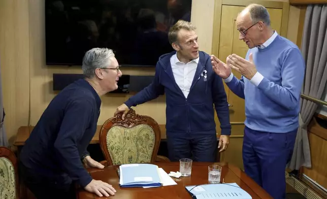 Britain's Prime Minister Keir Starmer, left, meets with French President Emanuel Macron, center, and German Chancellor Friedrich Merz onboard a train to Kyiv, in Shegyni, Ukraine, where all three will hold meetings with Ukrainian President Volodymyr Zelenskyy Friday, May 9, 2025. (Ludovic Marin, Pool Photo via AP)