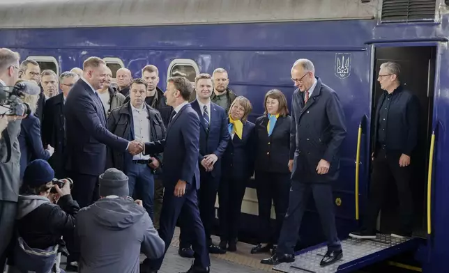 French President Emanuel Macron, 2nd left, Britain's Prime Minister Keir Starmer and German Chancellor Friedrich Merz are welcomed by an Ukraine official at their arrival at Kyiv railway in Ukraine, Saturday, May 10, 2025, where all three will hold meetings with Ukrainian President Volodymyr Zelenskyy. (Ludovic Marin, Pool Photo via AP)