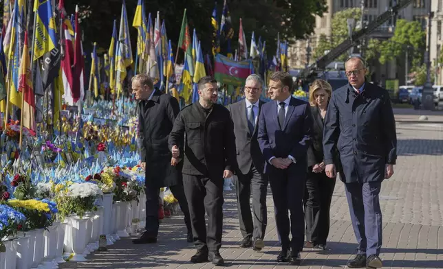 From left, Polish Prime Minister Donald Tusk, Ukrainian President Volodymyr Zelenskyy, U.K. Prime Minister Keir Starmer, French President Emmanuel Macron, German Chancellor Friedrich Merz arrive to put flowers on memorial of fallen Ukrainian soldiers at independence square in Kyiv, Ukraine, on Saturday, May 10, 2025. Ukraine's First Lady Olena Zelenska Olena Zelenska is seen behind, second right. (AP Photo/Evgeniy Maloletka)