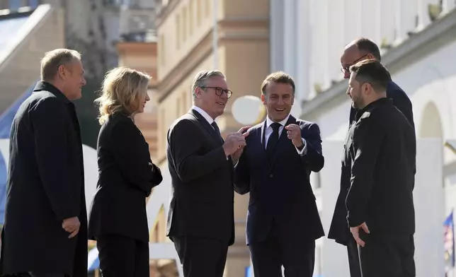 From left, Polish Prime Minister Donald Tusk, Ukraine's First Lady Olena Zelenska Olena Zelenska, U.K. Prime Minister Keir Starmer, French President Emmanuel Macron, German Chancellor Friedrich Merz, and Ukrainian President Volodymyr Zelenskyy, stand at the memorial of fallen Ukrainian soldiers at independence square in Kyiv, Ukraine, on Saturday, May 10, 2025. (AP Photo/Evgeniy Maloletka)