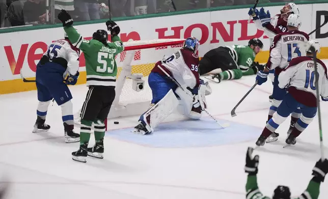 The Dallas Stars celebrate after Mikko Rantanen, laying against boards at rear, scored against the Colorado Avalanche's Mackenzie Blackwood (39) in the third period in Game 7 of a first-round NHL hockey playoff series Saturday, May 3, 2025, in Dallas. (AP Photo/Julio Cortez)