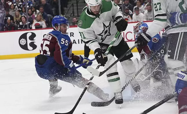 Dallas Stars center Tyler Seguin, center, shoots against Colorado Avalanche goaltender Mackenzie Blackwood, third from left, as Avalanche defenseman Ryan Lindgren (55) covers in the second period of Game 6 of an NHL hockey first-round playoff series Thursday, May 1, 2025, in Denver. (AP Photo/David Zalubowski)