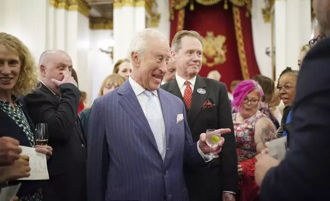 Britain's King Charles III speaks to guests during a reception in Buckingham Palace, London, in celebration of community-based initiatives raising awareness about cancer and supporting those living with cancer, Wednesday April 30, 2025. (Yui Mok/Pool Photo via AP)