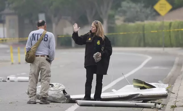 Investigators work at the site of a plane crash Friday, May 23, 2025, in San Diego. (AP Photo/Gregory Bull)