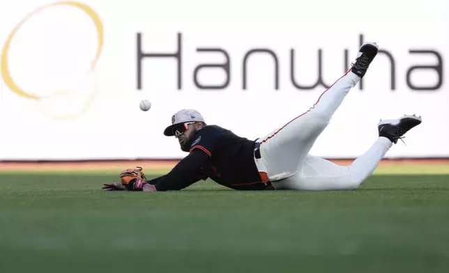 San Francisco Giants left fielder Heliot Ramos is unable to catch a fly ball hit by Athletics' Miguel Andujar for a single during the second inning of a baseball game Saturday, May 17, 2025, in San Francisco. (AP Photo/Godofredo A. Vásquez)