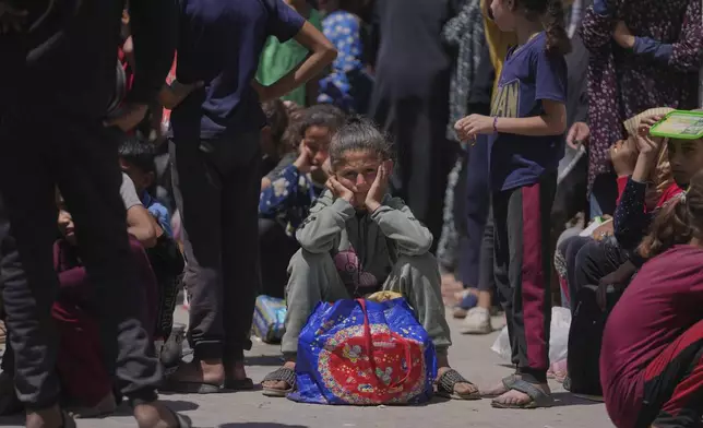 A Palestinian girl waits to collect donated food at a food distribution kitchen in Deir al-Balah, Gaza Strip, Friday, May 30, 2025. (AP Photo/Abdel Kareem Hana)