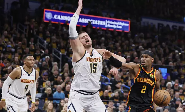 Oklahoma City Thunder's Shai Gilgeous-Alexander (2) works to the basket as Denver Nuggets' Nikola Jokic (15) and Russell Westbrook (4) defend in the second half of Game 1 of an NBA basketball second-round playoff series Monday, May 5, 2025, in Oklahoma City. (AP Photo/Nate Billings)