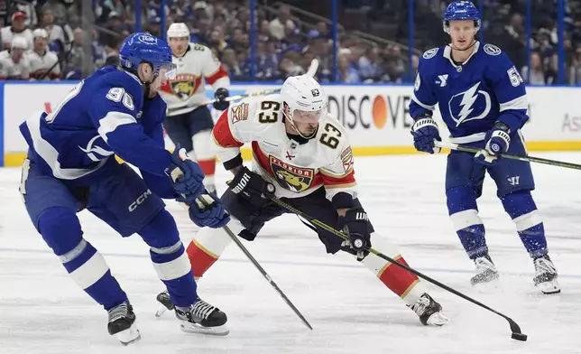 Florida Panthers center Brad Marchand (63) works against Tampa Bay Lightning defenseman J.J. Moser (90) during the third period in Game 5 of an NHL hockey Stanley Cup first-round playoff series, Wednesday, April 30, 2025, in Tampa, Fla. (AP Photo/Chris O'Meara)