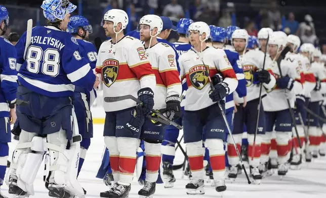 Tampa Bay Lightning goaltender Andrei Vasilevskiy (88) shakes hands with Florida Panthers center Sam Reinhart (13) after Game 5 of an NHL hockey Stanley Cup first-round playoff series, Wednesday, April 30, 2025, in Tampa, Fla. (AP Photo/Chris O'Meara)