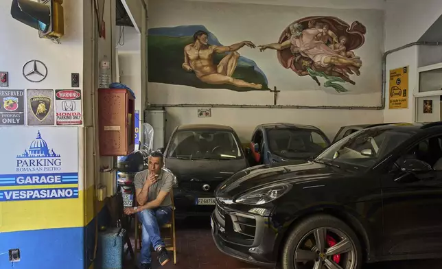 A reproduction of Michelangelo's "The Creation of Adam" is painted in a parking garage in Rome, Tuesday, May 6, 2025. (AP Photo/Bernat Armangue)