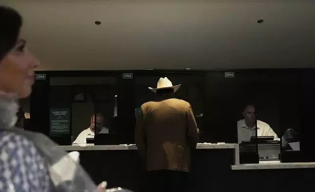 A person places a bet at Churchill Downs before the 151st running of the Kentucky Derby horse race Saturday, May 3, 2025, in Louisville, Ky. (AP Photo/Brynn Anderson)