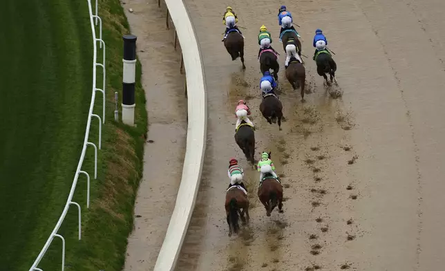 A race is run on a muddy track at Churchill Downs before the 151st running of the Kentucky Derby horse race Saturday, May 3, 2025, in Louisville, Ky. (AP Photo/Charlie Riedel)