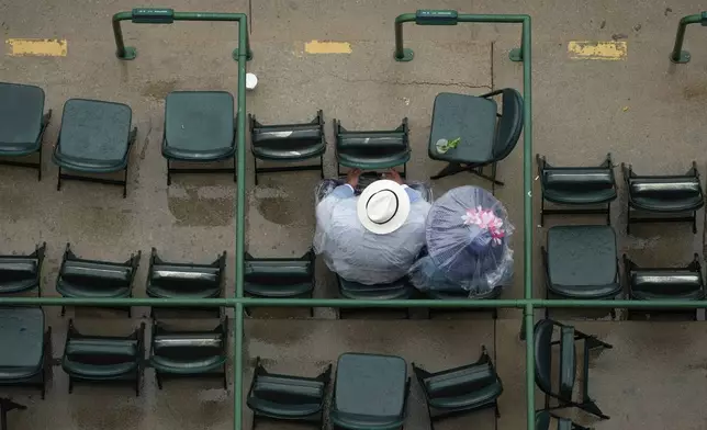 People sit in the stands at Churchill Downs before the 151st running of the Kentucky Derby horse race Saturday, May 3, 2025, in Louisville, Ky. (AP Photo/Charlie Riedel)