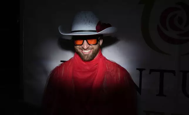 A person smiles at Churchill Downs before the 151st running of the Kentucky Derby horse race Saturday, May 3, 2025, in Louisville, Ky. (AP Photo/Brynn Anderson)