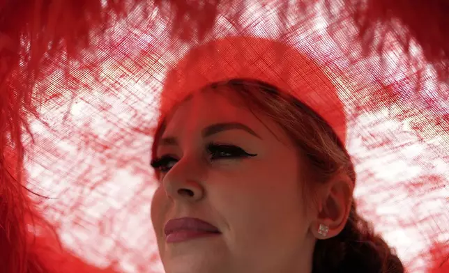A woman wears a hat while roaming the grounds at Churchill Downs before the 151st running of the Kentucky Derby horse race Saturday, May 3, 2025, in Louisville, Ky. (AP Photo/Brynn Anderson)
