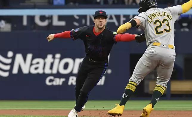 Toronto Blue Jays second baseman Ernie Clement (22) tags out Athletics' Shea Langeliers (23) in second inning MLB baseball action in Toronto on Friday, May 30, 2025. (Jon Blacker/The Canadian Press via AP)