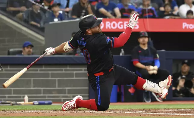 Toronto Blue Jays' Alejandro Kirk (30) loses his footing on a foul ball in second inning MLB baseball action against the Athletics in Toronto on Friday, May 30, 2025. (Jon Blacker/The Canadian Press via AP)