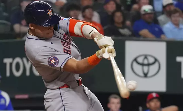 Houston Astros' Cam Smith hits a single that scored teammates Jake Meyers during the seventh inning of a baseball game against the Texas Rangers, Friday, May 16, 2025, in Arlington, Texas. (AP Photo/LM Otero)