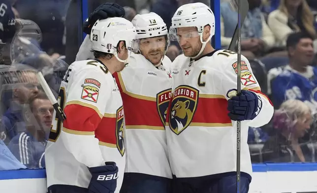 Florida Panthers center Sam Reinhart (13) celebrates his goal against the Tampa Bay Lightning with center Carter Verhaeghe (23) and center Aleksander Barkov (16) during the third period in Game 5 of an NHL hockey Stanley Cup first-round playoff series, Wednesday, April 30, 2025, in Tampa, Fla. (AP Photo/Chris O'Meara)