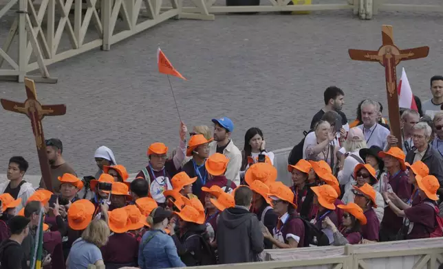 People arrive at St. Peter's Square at the Vatican where 133 cardinals gather on the second day of the conclave to elect successor of late Pope Francis, Thursday, May 8, 2025. (AP Photo/Markus Schreiber)
