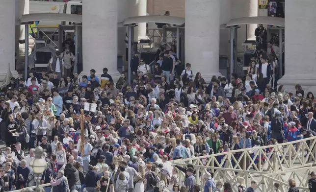 People arrive at St. Peter's Square at the Vatican where 133 cardinals gather on the second day of the conclave to elect successor of late Pope Francis, Thursday, May 8, 2025. (AP Photo/Markus Schreiber)