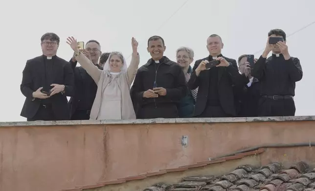 Clergy watches as the black smoke billows from the chimney of the Sistine Chapel where 133 cardinals are gathering on the second day of the conclave to elect a successor to late Pope Francis, at the Vatican, Thursday, May 8, 2025(AP Photo/Markus Schreiber)