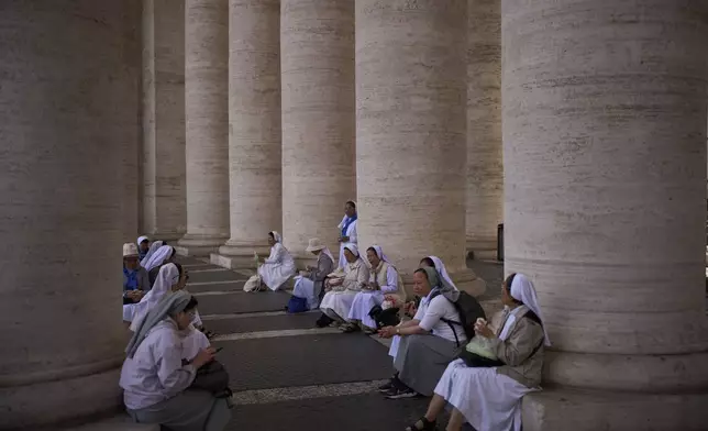 Nuns from Vietnam eat their lunch at St. Peter's square during the cardinals' conclave to elect a new pope, at the Vatican, Thursday, May 8, 2025. (AP Photo/Emilio Morenatti)