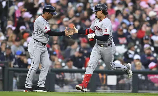 Cleveland Guardians' Bo Naylor, right, celebrates with third base coach Rouglas Odor, left, as he circles the bases after hitting a home run against the Detroit Tigers in the third inning of a baseball game Saturday, May 24, 2025, in Detroit. (AP Photo/Lon Horwedel)