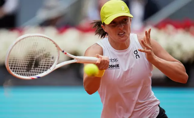 Iga Swiatek of Poland returns the ball against United States' Madison Keys during the Madrid Open tennis tournament in Madrid, Spain, Wednesday, April 30, 2025. (AP Photo/Manu Fernandez)