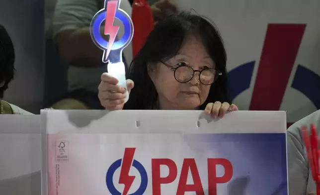 Supporters of ruling party People's Action Party (PAP) wave logo of PAP as they wait for results of the general election at a stadium in Singapore, Saturday, May 3, 2025. (AP Photo/Vincent Thian)
