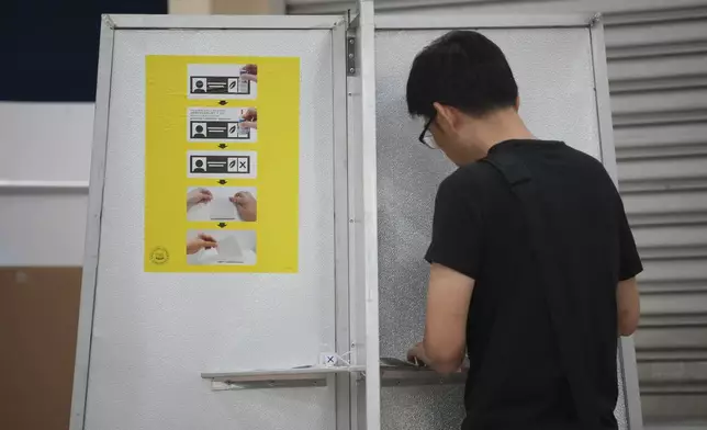 A Singaporean voter casts a vote for general election at polling station in Singapore, Saturday, May 3, 2025. (AP Photo/Vincent Thian)